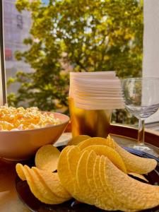 a plate of crisps and a bowl of chips and a glass at Nice 1Room Condo WarszawaCenter in Warsaw