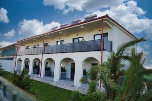 a white building with a balcony on top of it at Vila Luna in Vama Veche