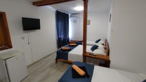 a hotel room with two beds and a television at Holiday House Costinesti in Costinesti