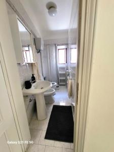 a white bathroom with a sink and a toilet at Alba -vista unica con terrazza- in Siena