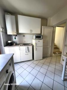 a kitchen with white cabinets and a dishwasher at Alba -vista unica con terrazza- in Siena