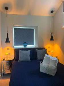 a bedroom with a blue bed and a window at Arkle in Kelling +16 photos