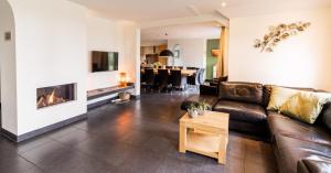 a living room with a couch and a fireplace at Hof van Salland Hellendoorn in Hellendoorn