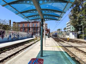 a train station with a blue shelter on the tracks at Hotel Nuvò in Naples
