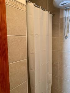 Una ducha con una cortina de ducha blanca en un baño. en Apartments Boffi, en Ulcinj