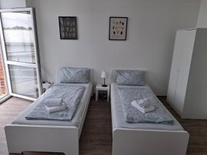 una camera con due letti con cuscini sopra di CityOase Magdeburg Studios am Königsweg, Studio 4, WiFi, Stellplatz, Netflix a Magdeburgo