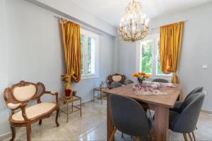 a dining room with a table and chairs and a chandelier at Villa Angelique in Sinarádes