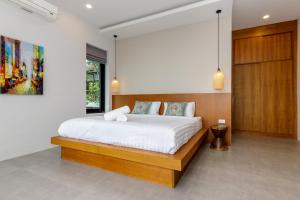 Un dormitorio con una cama con cabecero de madera. en 2br sea view pool villa D, en Hinkong