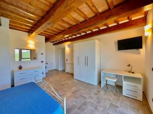 a bedroom with a bed and a desk and a tv at Panorama-Ferien-Toscana Your cozy and fully equipped vacation home in Massa Marittima