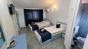 a small room with two beds and a bathroom at Holiday House Costinesti in Costinesti