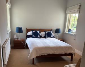 a bedroom with a bed with blue and white pillows at 7 Oakwood Manor Kenmare in Kenmare