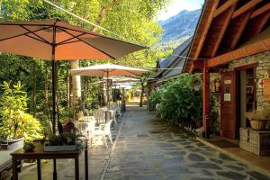 a patio with umbrellas and tables and chairs at Camping Bedura Park in Era Bordeta