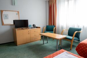 a room with two chairs and a table and a tv at Hotel Wilanów in Warsaw +18 photos