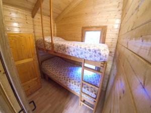 a bedroom with two bunk beds in a wooden cabin at Camping Bedura Park in Era Bordeta