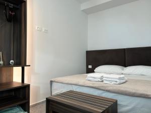una camera da letto con un letto con asciugamani sopra di OLEA Family Apt with Garden a Dhërmi
