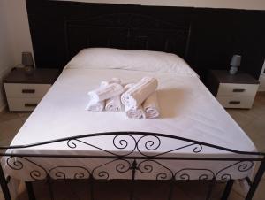 1 cama con toallas blancas y 2 mesitas de noche en Casa vacanze da viola, en Ugento