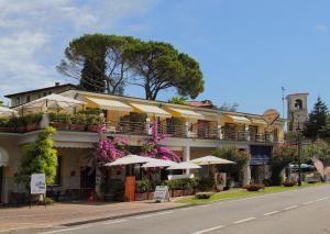 ein Gebäude mit Regenschirmen am Straßenrand in der Unterkunft Edonè Al Lago in Gardone Riviera