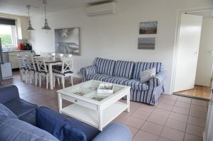 a living room with a couch and a table at Kustverhuur, Vakantiepark Fort Soleil 60 in Breskens