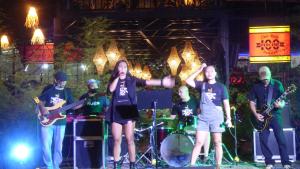 a group of people on a stage playing music at Cafe Moto Hostel in Puerto Princesa City