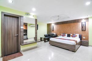a bedroom with a king sized bed and a sliding door at FabHotel Raj Residency II in Rānchī