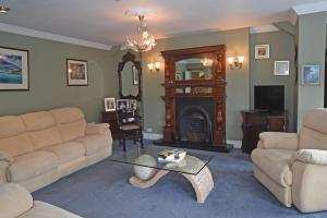 a living room with a couch and a fireplace at Clooneen House in Westport