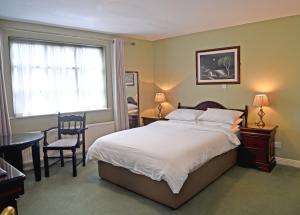 a bedroom with a bed and a table and a window at Clooneen House in Westport