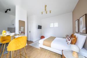 a bedroom with a bed and a desk and chairs at Studio proche Paris Expo Porte de Versailles in Issy-les-Moulineaux