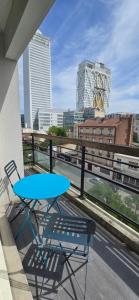 a table and chair on a balcony with a view of a city at Bel appartement près du métro in Saint-Denis
