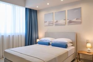 雅典Acropolis Muses - Downtown Luxury Apartments的一间卧室，床上有两个蓝色枕头