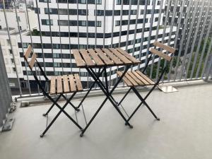 2 sedie in legno e un tavolo sul balcone di Whats-App Self-Check-IN - Pärchen Wohnung am Hauptbahnhof a Vienna