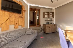 un soggiorno con divano e TV a parete di Guest House Nikala a Mestia