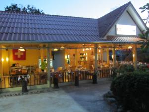 a restaurant with tables and chairs in front of it at Flower Paradise Bungalows & Swiss Restaurant Roestiland in Lamai