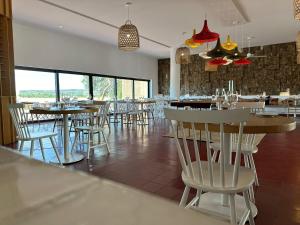 uma sala de jantar com mesas, cadeiras e janelas em The Lince Ecorkhotel Évora em Évora
