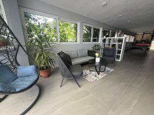 a screened in porch with a couch and chairs and a table at Dela in Hvar