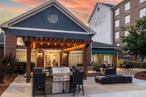 an outdoor entertaining area with a grill and chairs at Homewood Suites Fredericksburg in Fredericksburg