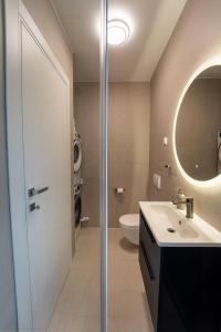 Un baño con lavabo, espejo e inodoro. en Rooftop Holiday House, en Brodarica