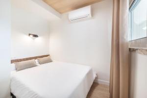 a bedroom with a white bed and a window at Cascais Lofts by Olala Homes in Cascais