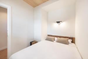 a bedroom with white walls and a white bed at Cascais Lofts by Olala Homes in Cascais