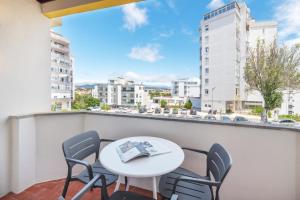 a table and chairs on a balcony with a view of a city at Cascais Lofts by Olala Homes in Cascais