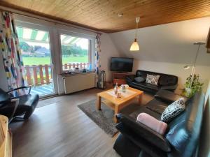a living room with a couch and a table at Ferienwohnung Mona, 65314 in Moormerland