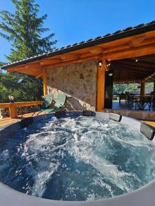 a hot tub in the middle of a patio at Fox Wood House in Ciobotani