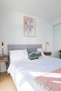 a bedroom with a white bed with a pink blanket at 2 Bedroom 2 bath 1 Car on Lonsdale Street in Canberra +23 photos