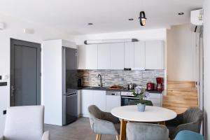 a kitchen and dining room with a table and chairs at Lefkadian Gem Villas in Áyios Nikólaos Nirás