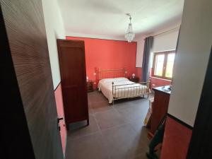 Un dormitorio con una cama y una pared roja. en Casa Vacanza da zio Minguccio, en Castellaneta Marina 10 fotos más