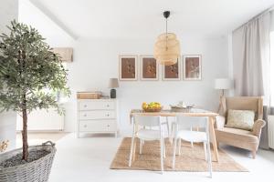 a white living room with a table and chairs at Dom Nad Narwia in Serock