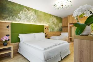 a bedroom with a white bed and a green wall at Residence Hotel Miralago in Pergine Valsugana