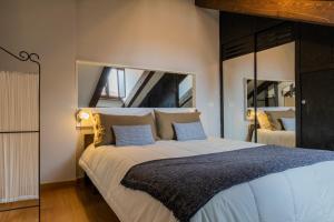 a bedroom with a large bed with two mirrors at Barbaroux Apartments by Wonderful Italy in Turin