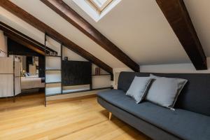 a living room with a blue couch and a window at Barbaroux Apartments by Wonderful Italy in Turin