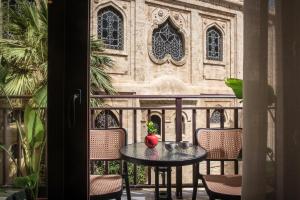 une table avec un vase sur le balcon dans l'établissement Centro Vero Suites by Omilos Hotels, à Héraklion