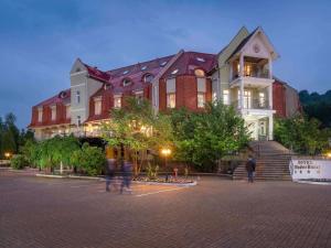 梅迪亚什Mercure Medias Binderbubi Hotel And Spa的一座大楼，前面有人走动
